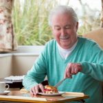 Happy senior man enjoying his breakfast