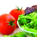 Tomatoes and lettuce being prepared for a salad