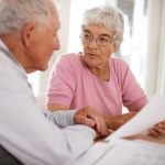 Cropped shot of two elderly people discussing a document